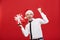 Christmas Concept - portrait happy Santa christmas businessman exciting with his gift over red background.