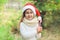 Christmas concept - portrait little girl child in santa red hat with sweet lollipop cane