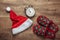 Christmas concept. Santa hat, sleeping slippers, alarm clock on the floor. Top view