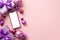 Christmas concept. Top view photo of smartphone purple gift boxes with ribbon bows pink violet baubles and confetti on isolated