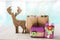 Christmas concept, Wood reindeer with blurred gift and gift in brown shopping bag over blurred blue water background