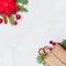 Christmas corner composition. Red stars, gift, holly berries and green fir branch on white background. Xmas flat lay top view