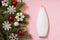 Christmas cosmetic on pink background, winter shampoo or body gel with fir branches and snowflakes