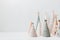 Christmas craft background with handmade yarn cone xmas trees in natural colors.