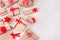 Christmas craft paper gifts with red ribbons closeup and bows on soft white wood table, top view, border.