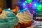 Christmas cream cakes and candles close up on the table with colored lights