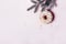 Christmas creative background. Christmas ball made of decorated donut hanging on Christmas tree branch