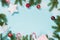 Christmas creative border with red balls, snowflakes and branches on blue background. Flat lay. Top view. Copy space.