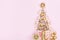 Christmas creative fir tree from champagne, confetti stars and serpentine with gift box on pink background top view. Flat lay.