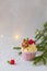 Christmas cupcakes or muffins with cream and raspberry, over the fir tree branches background