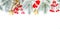 Christmas decor border. Green Xmas fir branch, gold stars, red holly berries and glass baubles isolated on white background