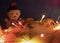 Christmas Decor Close-up with Glowing Pink, Yellow, Orange Lanterns on the Background of a Snowman. Colorful Christmas Lights on a