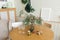 Christmas decor in the living room: two glasses on the table, spruce branches in a vase and candles