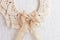 Christmas decor. Macrame wreath for Christmas and the new year on a white decorative plaster wall. Natural cotton thread, linen
