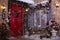 Christmas decor on a patio. Doors are decorated by a festive chaplet and toys. Fir-tree at a window