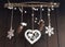 Christmas decor on a wooden brown wall background. Cones, heart, berries and stars hanging on the ropes on the branch