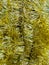 Christmas decor yellow tinsel blurred background, top view. New Year`s background. Christmas background