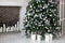 Christmas!  Decorated living room with fireplace with beautiful Christmas tree and balls. Christmas gift boxes on floor near fir t