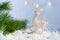 Christmas decoration on abstract twinkling lights background, soft focus. Silver deer on the snow against a background of blurry l