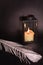 Christmas decoration on black background. Lantern, candle, silver feather