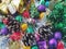 Christmas decoration collection. Beautifully arranged shiny bright Christmas tree decorations, green foil, gifts. Red, purple,