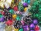 Christmas decoration collection. Beautifully arranged shiny bright Christmas tree decorations, green foil, gifts. Red, purple,