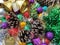 Christmas decoration collection. Beautifully arranged shiny bright Christmas tree decorations, green foil, gifts. Red, purple,