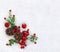 Christmas decoration. Cones pine, twigs christmas tree, red berries and apples on snow with space for text. Top view, flat lay