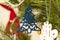 Christmas decoration figurine of a shiny flat blue tree on a pine branch. New Year`s atmosphere. Festive background