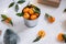 Christmas decoration of mandarin in an iron small bucket, Christmas tree, gifts and a luminous garland on the white wooden boards.