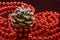 Christmas decoration with a pine cone and a shiny red beaded garland