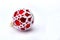 Christmas decoration. Red ball with white openwork on snow on white background