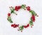 Christmas decoration. Red berries on twigs and apple on snow with space for text. Top view, flat lay