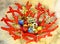 Christmas decoration: Red coral shape vase with multicolor Christmas balls, little bells and garland with golden stars on sheep