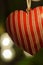 Christmas decoration. Red heart hanging on xmas tree. Lights. Background bokeh.