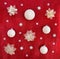 Christmas decoration. White balls, white openwork flowers, snowflakes on red glitter background. Top view, flat lay