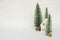 Christmas decoration with white house and conifers on white background with bokeh atmosphere. A metaphor for a mountain house on a