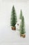 Christmas decoration with white house and conifers on white background with bokeh atmosphere. A metaphor for a mountain house on a