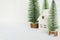 Christmas decoration with white house and conifers on white background with bokeh atmosphere. A metaphor for a mountain house on a