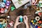 Christmas decorations, balls, toy and gift boxes on old wooden board. Female hands draw New Year decorations.