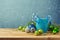 Christmas decorations with blue cup on wooden table over bokeh dreamy background