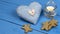 Christmas decorations on a blue table: cookies, candle, heart toy