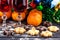 Christmas decorations on a dark wooden background, pastries, biscuits, tangerines, champagne wine in transparent glasses