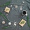 Christmas decorations, evergreen tree branch, coffee cup and gifts on gray plaid. Flat lay, top view. Christmas, New Year, winter