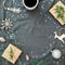 Christmas decorations, evergreen tree branch, snowflakes, coffee cup and gifts on gray plaid. Flat lay, top view. Christmas winter