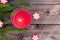 Christmas decorations, fir branches and red flaming candle on vintage wooden board background with copy space