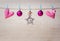 Christmas decorations and hearts hanging on rope on wooden background