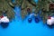 Christmas decorations made of artificial spruce, balloons with snow and berries, cones, bells, icicles on a blue background. New y