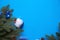 Christmas decorations made of artificial spruce, balloons with snow and berries, cones, bells, icicles on a blue background. New y