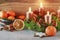 Christmas decorations - wreath with candles, bowl with oranges, wooden stars